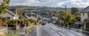 Everyday rural Ireland with scattered homes, a nearby village, residents, local roads and transport illustrating how access matters more than distance.
