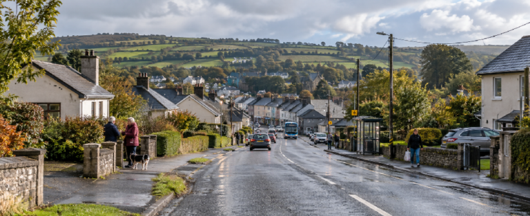 Everyday rural Ireland with scattered homes, a nearby village, residents, local roads and transport illustrating how access matters more than distance.